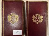deux livres aux couvertures dorées et rouges posés sur une table