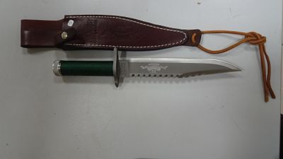 un couteau muni d'un étui en cuir, accroché au mur