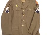 an army uniform jacket with patches on the sleeves and shoulder