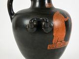 a black vase with an orange design on it