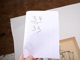 a person holding a piece of paper with a number on it