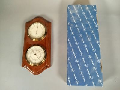 une horloge en bois et une boîte posées sur une table