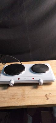 a white stove top with two burners on a wooden table