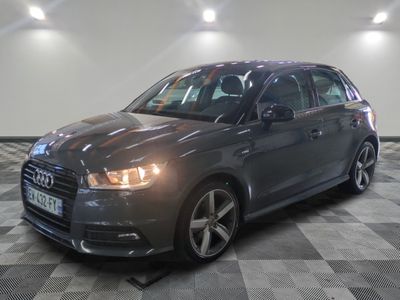 L'Audi grise est garée dans une pièce dont le sol est en damier.