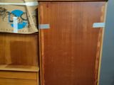 a wooden cabinet with a basket on top of it