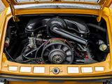 a small yellow car with a large engine in it ' s trunk