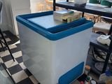 a blue and white cooler sitting on a black and white checkered floor