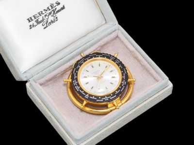 une montre dorée et noire dans un coffret, sur fond noir