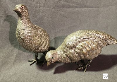 two birds that are standing next to each other on a table