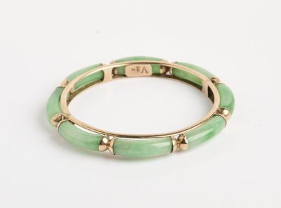 un gros plan d'un bracelet vert posé sur une surface blanche