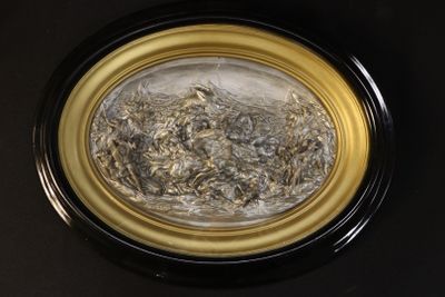 a picture of a black and gold plate with a pile of dried flowers in it