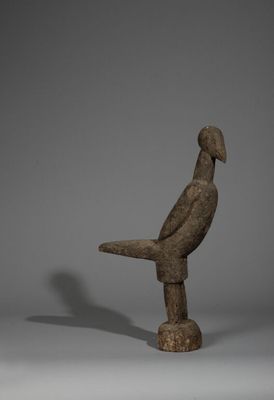 une image représentant une statue d'oiseau posée sur un bloc de bois