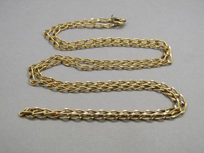 a close up of a gold chain on a gray surface