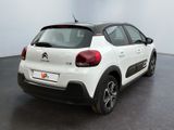 the rear end of a white citrole parked in a room