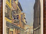 painting of a street scene with buildings and a clock in a frame