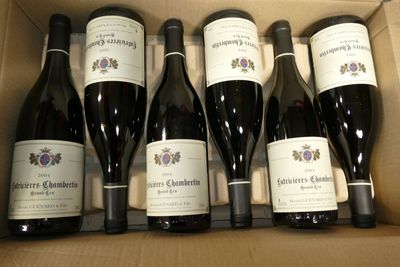 six bouteilles de vin dans un carton sur la table