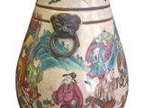 a vase with a painting on it that is sitting on a table