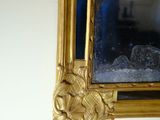 a mirror hanging on the wall with a person taking a picture