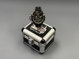 a watch sitting on top of a suitcase on a table
