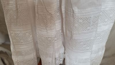 une robe blanche suspendue à un portant dans une pièce