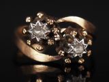 gros plan d'une bague en or et diamants sur une surface noire