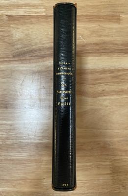 un livre noir orné de lettres dorées, posé sur une table en bois