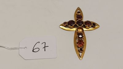 un gros plan d'une croix en or ornée de grenats