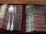 many forks and spoons in a box on the table