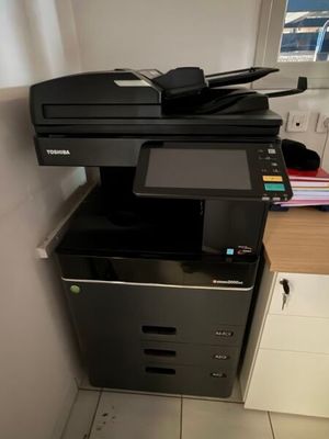 une imprimante noire posée sur un classeur noir