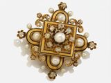 an image of a brooch with pearls and gold on a white background