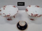 une paire de bols et de soucoupes en porcelaine décorés de fleurs rouges