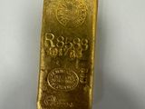 a gold bar sitting on top of a white surface