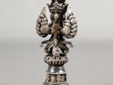 an antique silver figurine of a bird on a pedestal