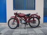a red motorcycle parked in front of a building