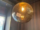 a glass ball hanging from the ceiling of a restaurant