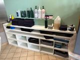 a bathroom with a lot of bottles and towels on the shelf