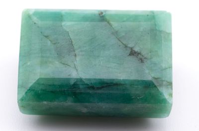 gros plan d'une pierre d'émeraude verte sur une surface blanche