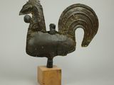 statue d'un coq posée sur un socle en bois, sur fond blanc