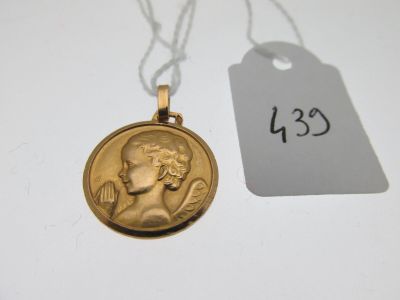 une image représentant une médaille d'or suspendue à une chaîne, avec une étiquette de prix