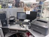 un bureau sur lequel se trouvent un ordinateur et une imprimante, dans un magasin