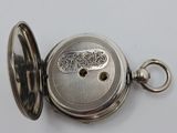 a silver pocket watch with a chain on a white surface