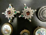 several pieces of jewelry on a black surface with a coin in the background