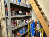 a shelf full of paint and other items in a garage