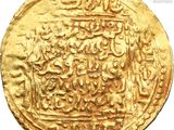 a close up of a gold coin with arabic writing on it