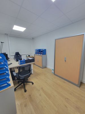 une pièce avec un bureau, des chaises et une porte