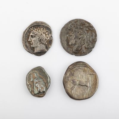 trois pièces romaines, dont l'une représente une tête et l'autre un visage