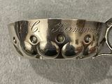a silver spoon with a handle that has a design on it