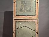 an old wooden cabinet sitting on top of a wooden floor next to a gray wall