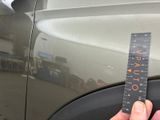 a hand holding a ruler that is on the side of a car