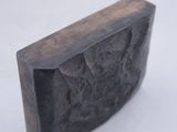 a black block of soap sitting on a white surface